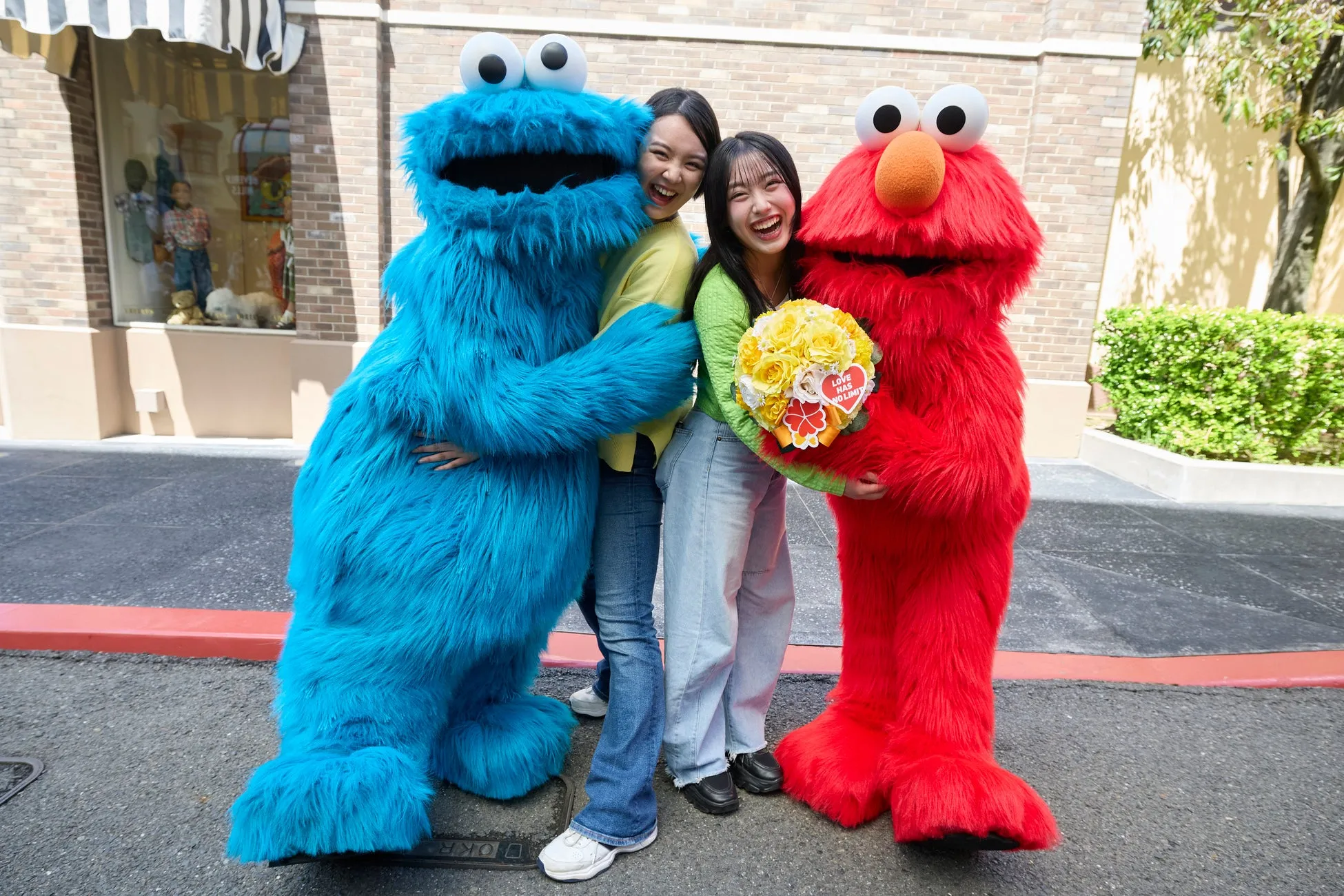 USJでキャラクターと女性が花束を持ち笑顔