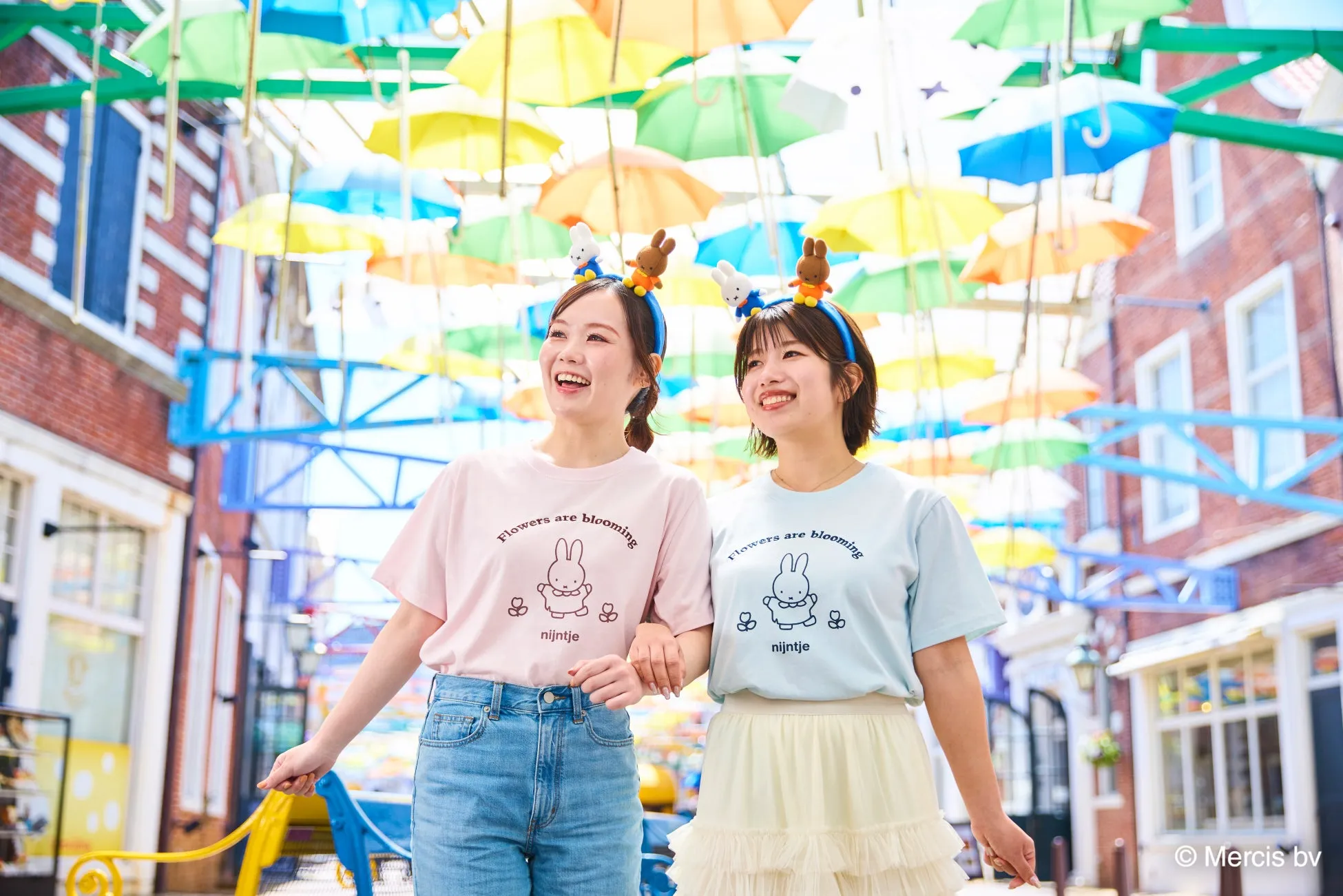 ミッフィーのTシャツを着た女性たちとカラフルな傘の装飾