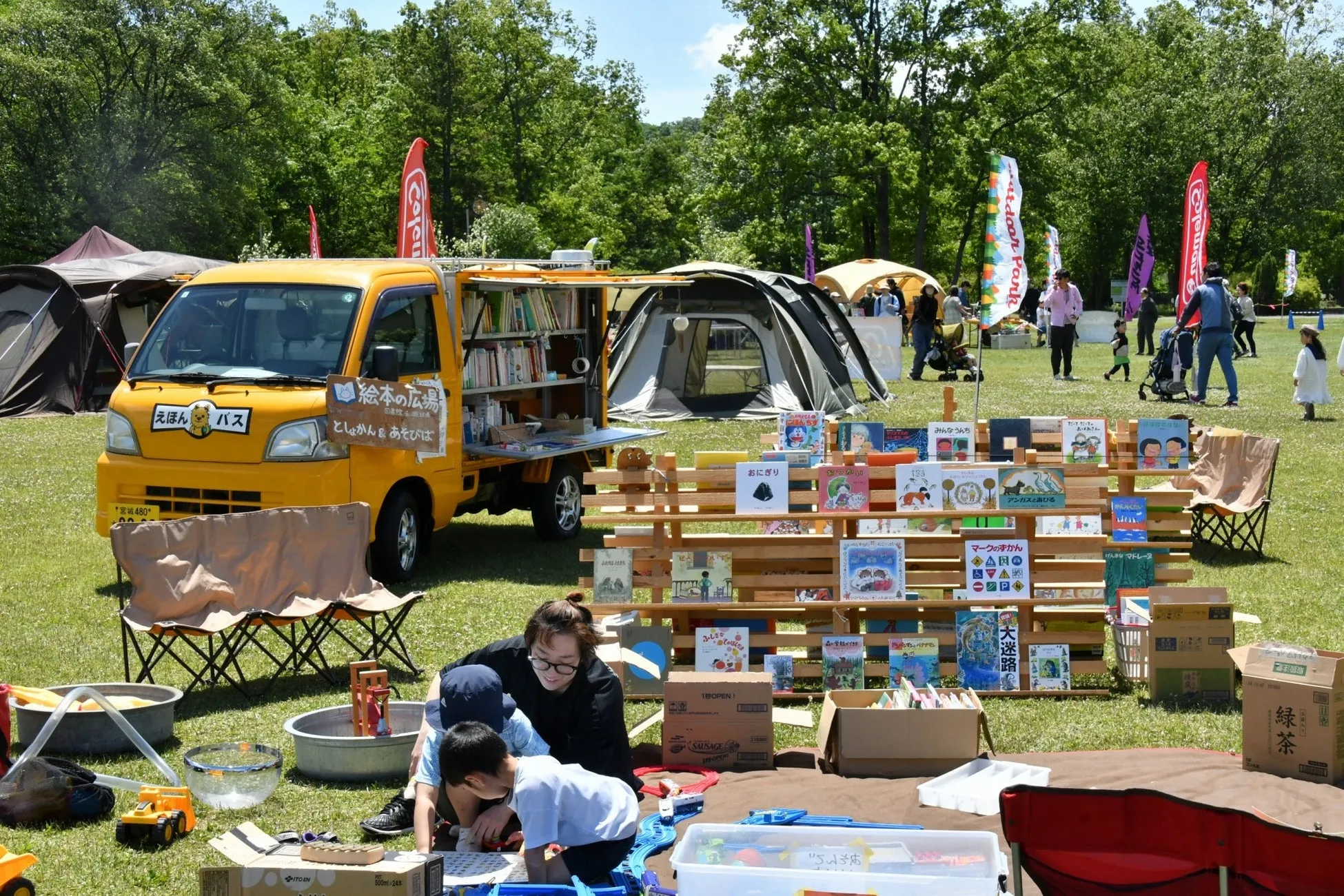 移動図書館車と絵本が並ぶアウトドアイベントの風景