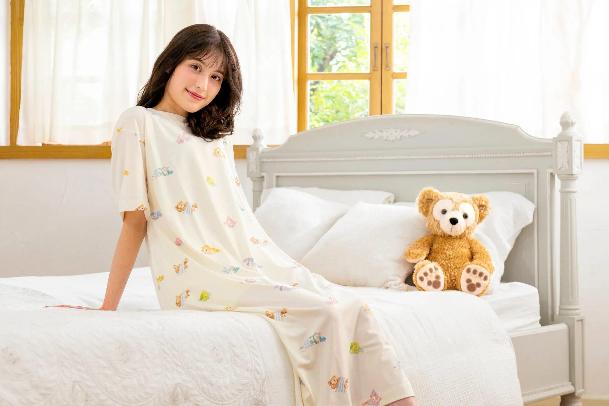 gelato piqueのダッフィー&フレンズデザインのルームウェアを着た女性とダッフィーのぬいぐるみ
