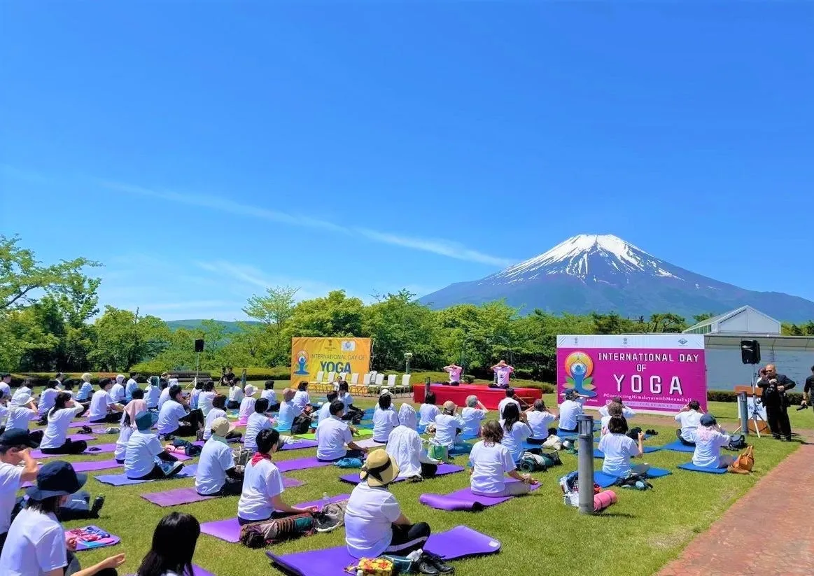 富士山を背景にヨガをする人々