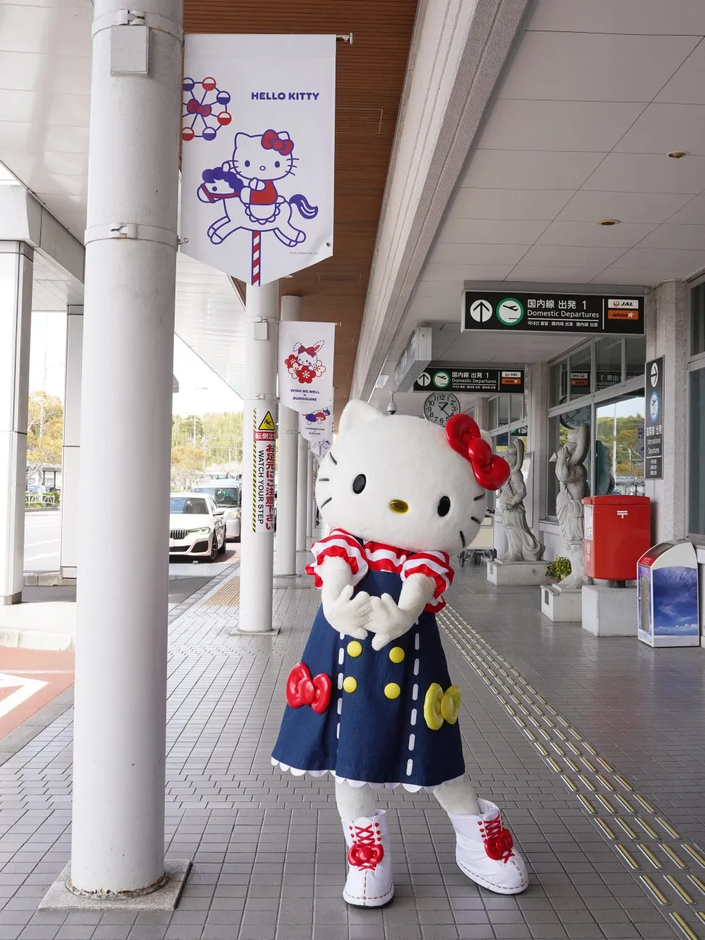 ハローキティが空港でポーズ
