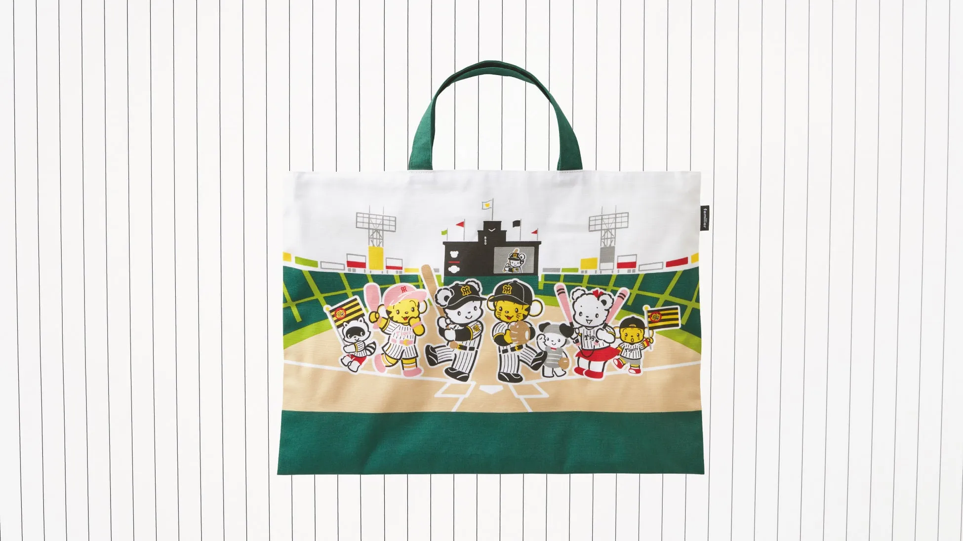 ファミリアと阪神タイガースのマスコットが集合したデザインのレッスンバッグ