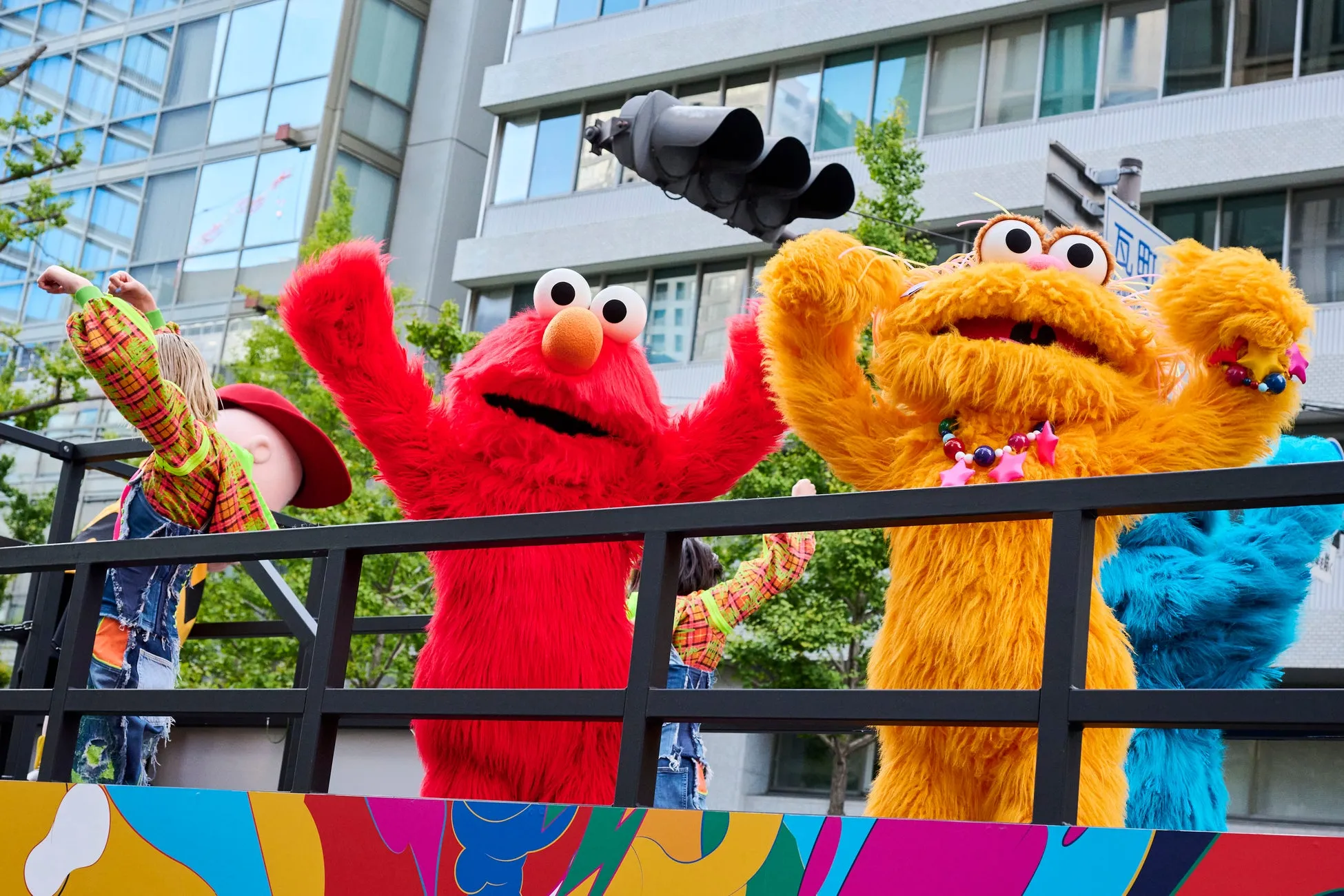 カラフルなキャラクターたちがパレードで手を振る