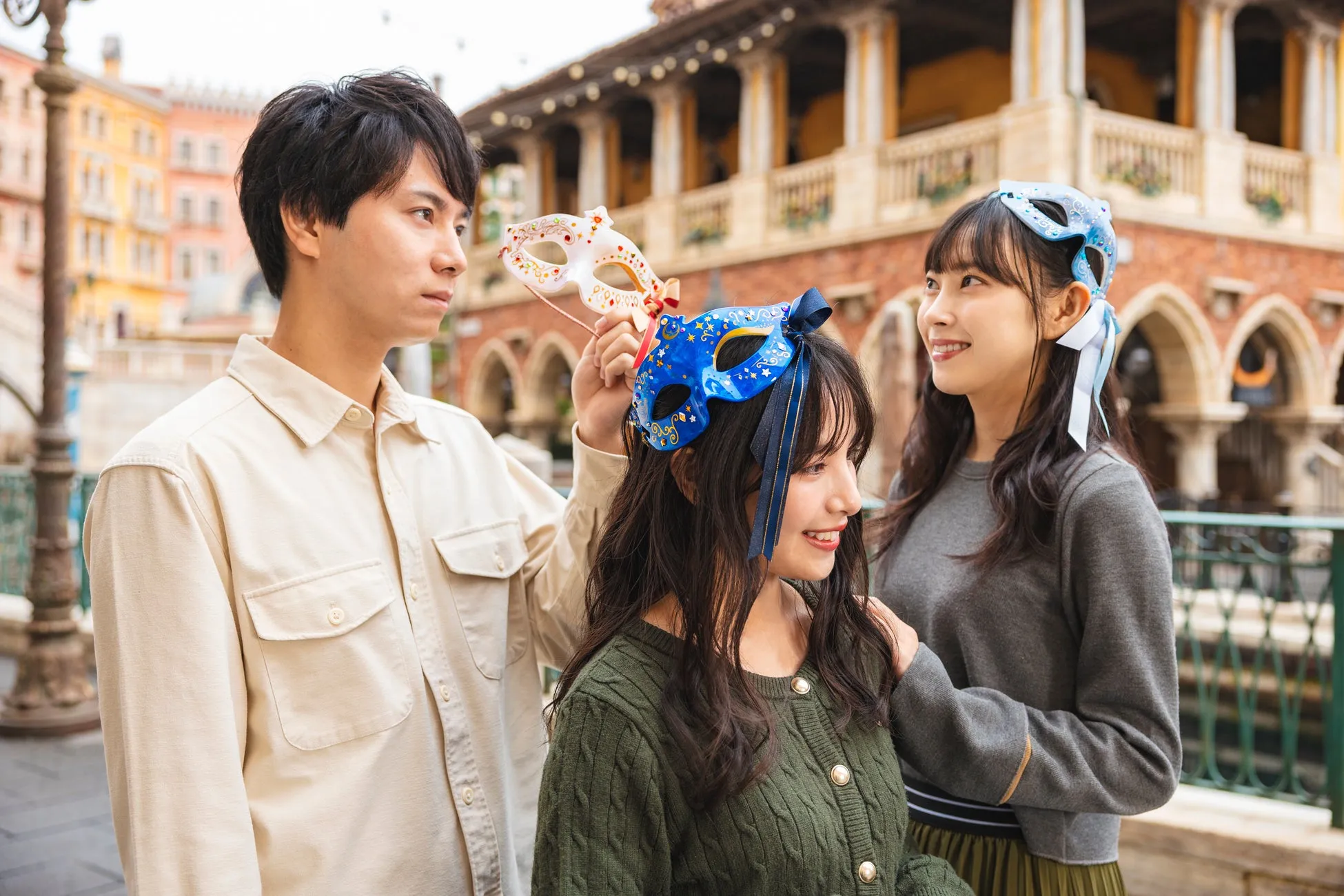 テーマパークでマスクを持つ若者たち