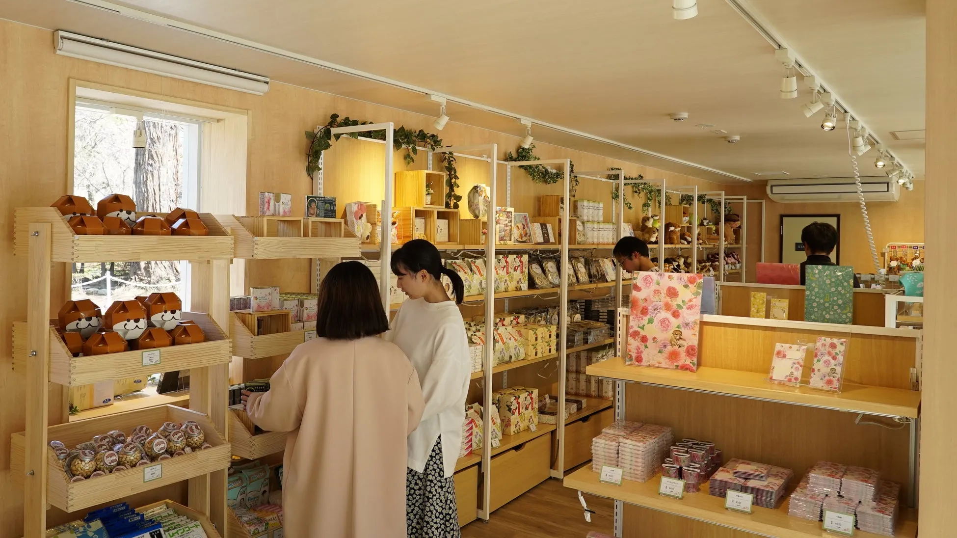 お土産ショップの内部で商品を選ぶ人々