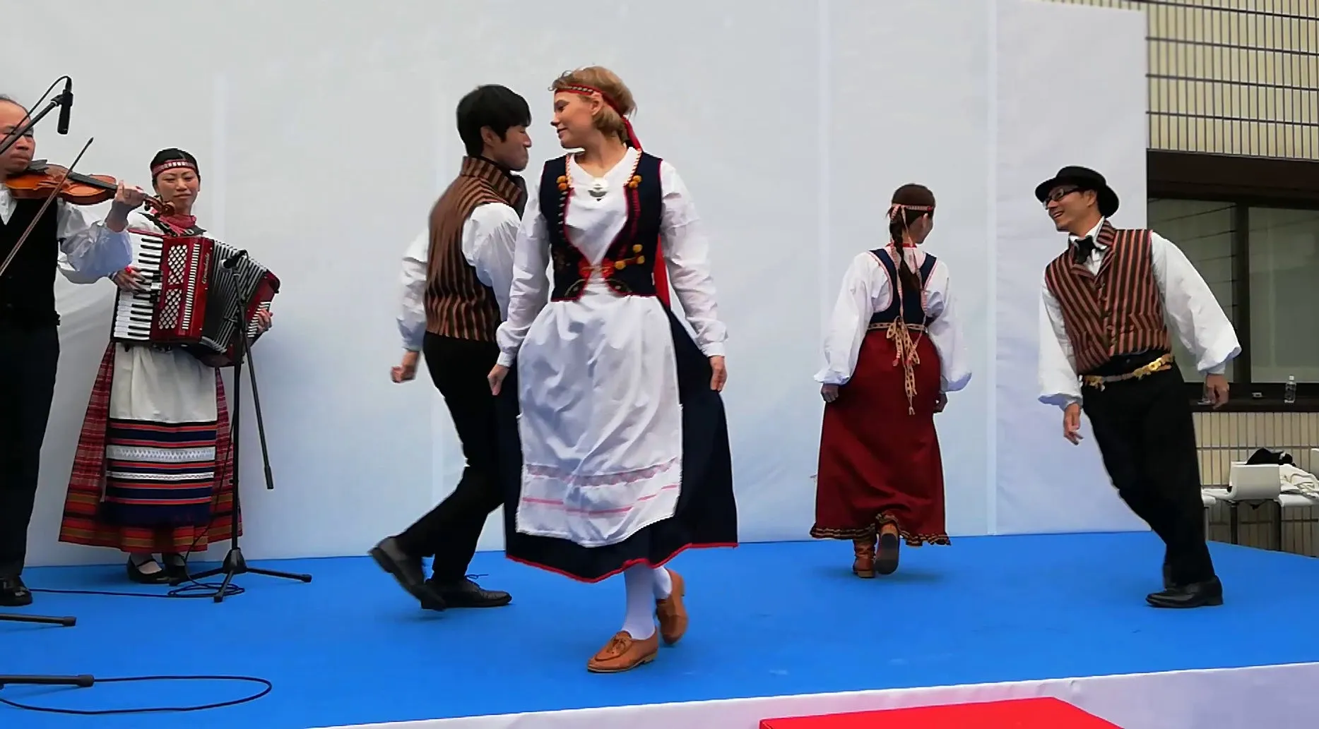 民族衣装で踊る人々と演奏するミュージシャン