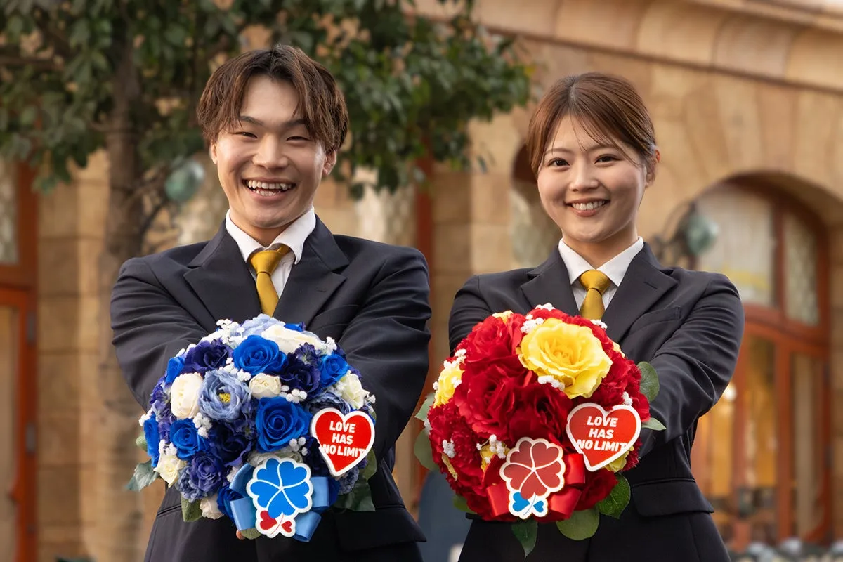 ユニバーサル・スタジオ・ジャパンのスタッフが青と赤の花束を持って笑顔