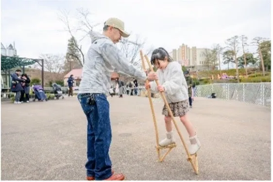 西武園ゆうえんちで竹馬を楽しむ親子