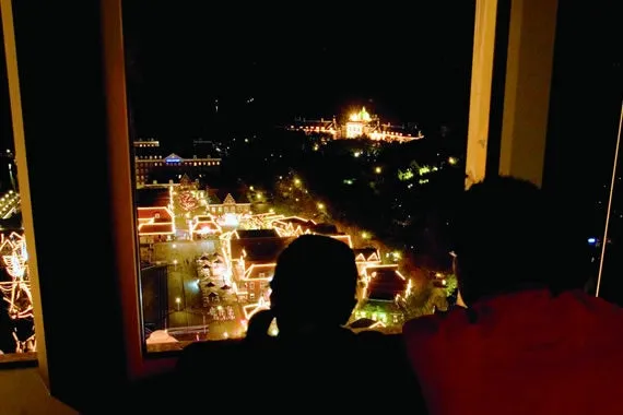 夜景を窓から眺める人々のシルエット
