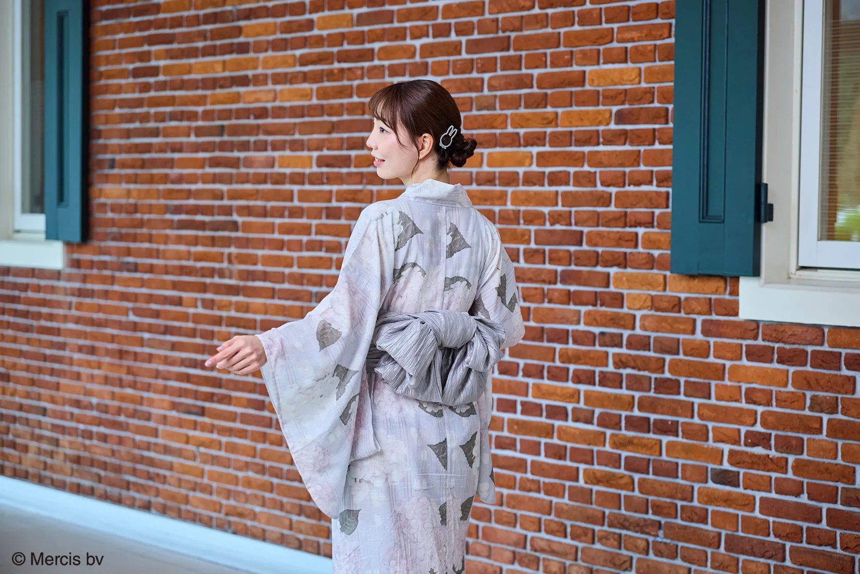 和装の女性とレンガの壁