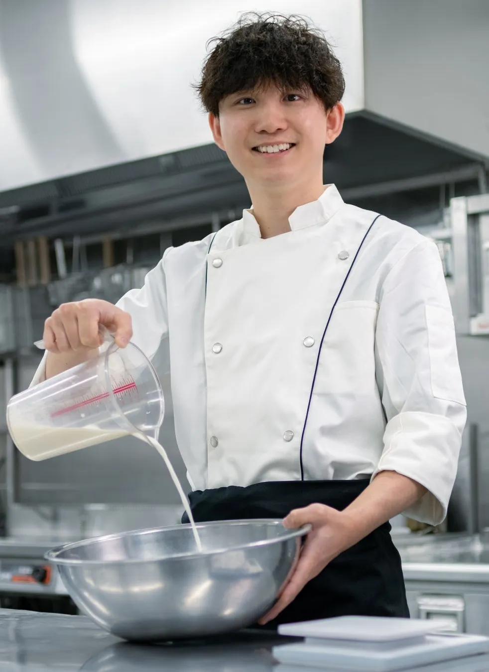 シェフがボウルにミルクを注ぐ様子