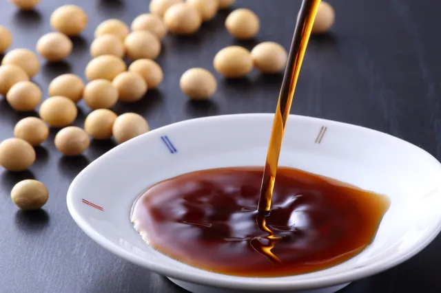 醤油が注がれる白い小皿と豆