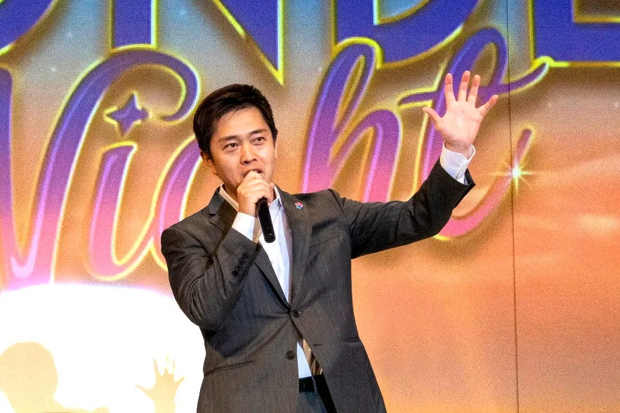 スピーカーがステージでマイクを持ってスピーチ