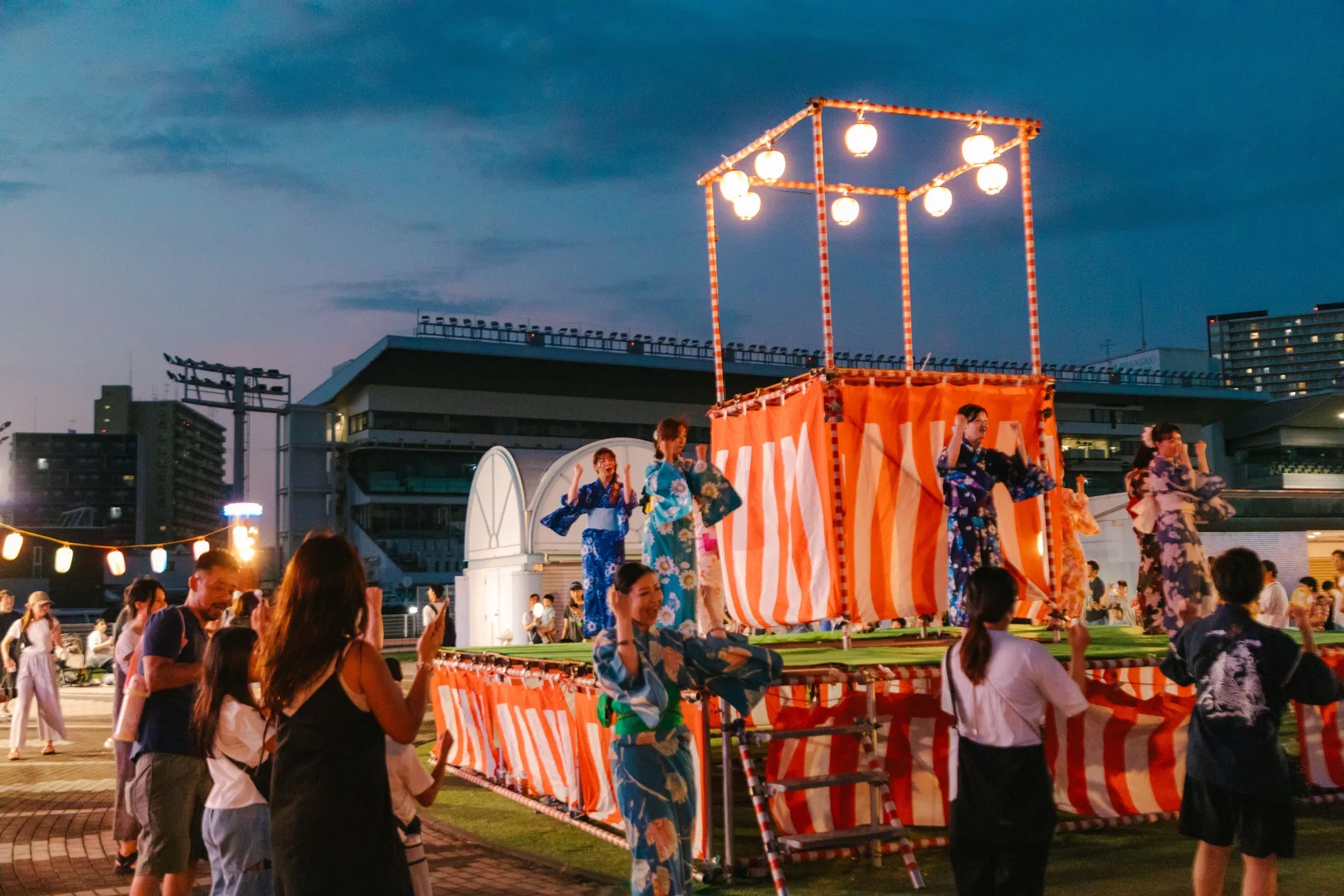 川崎競馬場の夏夜祭で盆踊りをする人々
