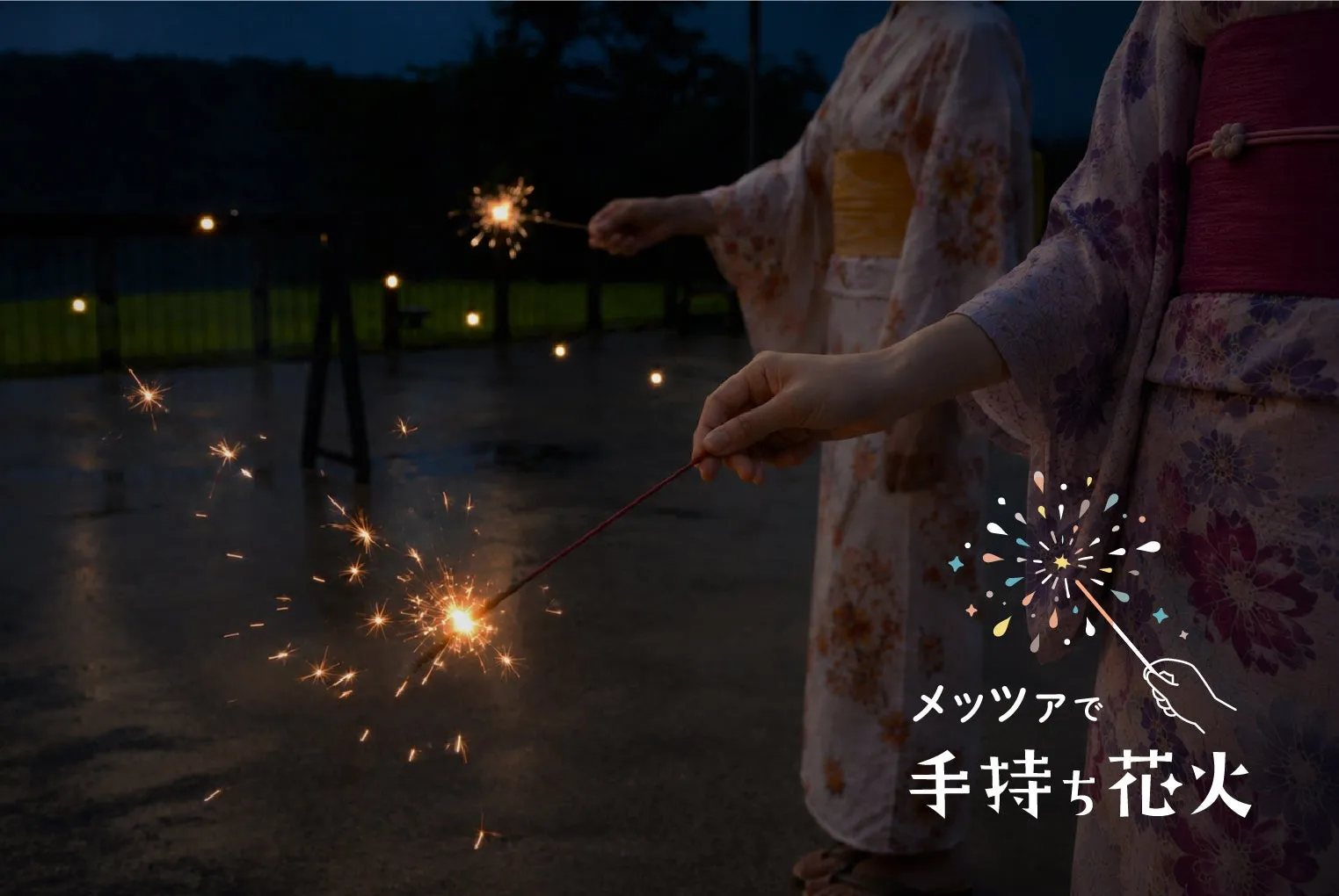 浴衣を着た女性が手持ち花火を楽しむ場面