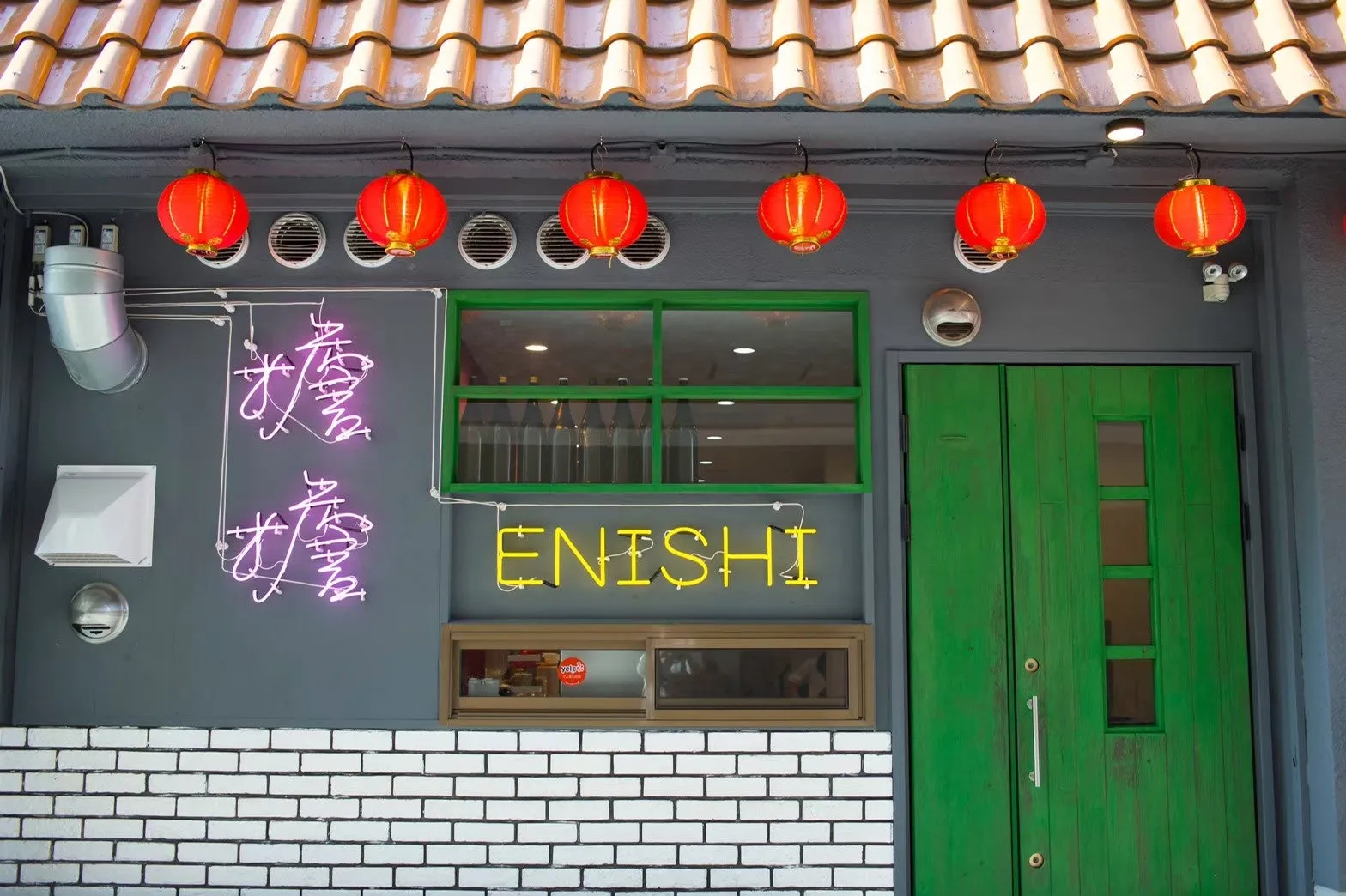 担担麺専門店ENISHIの外観、赤い提灯とネオン看板が特徴