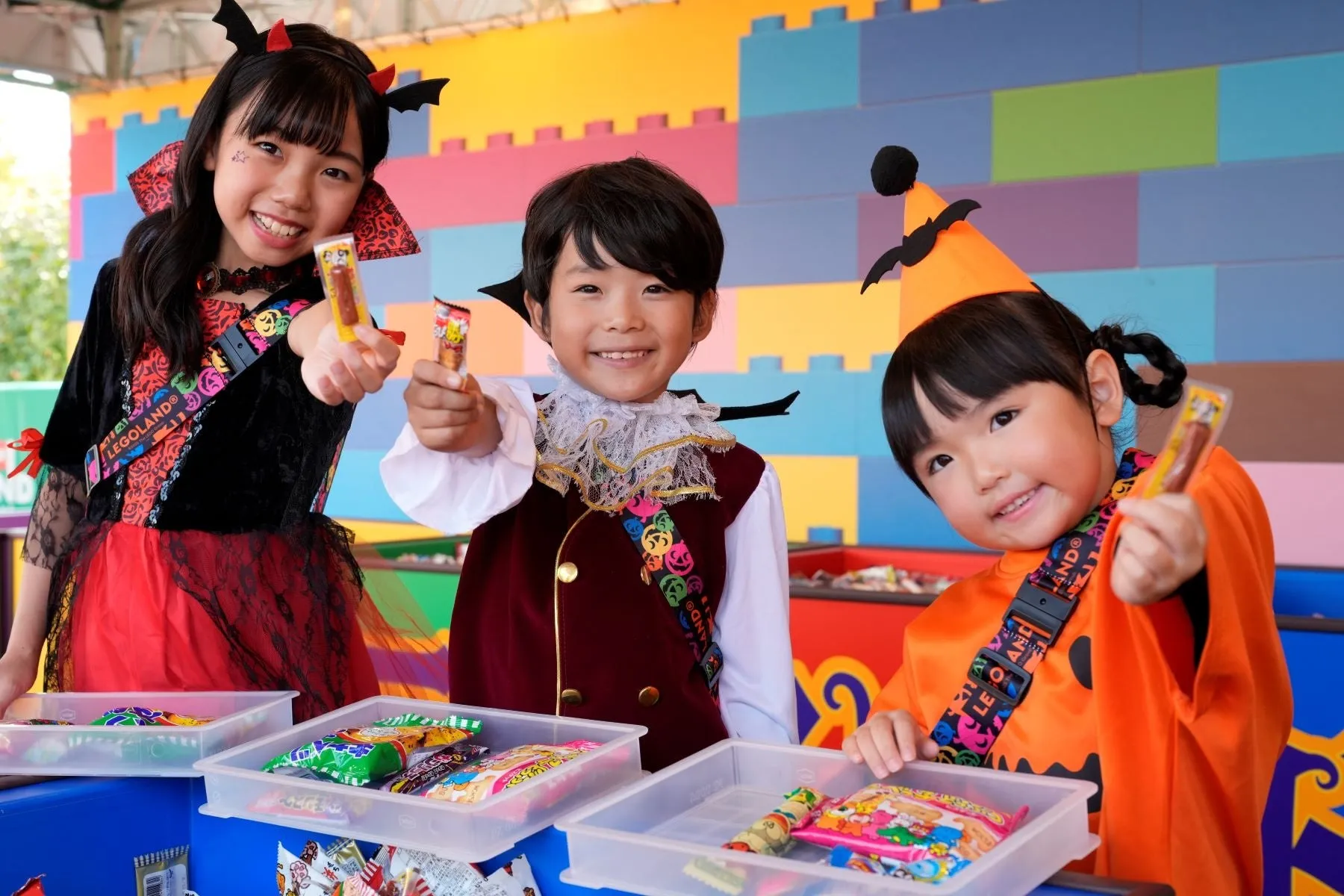 ハロウィン仮装をした子供たちがお菓子を持って微笑んでいる様子