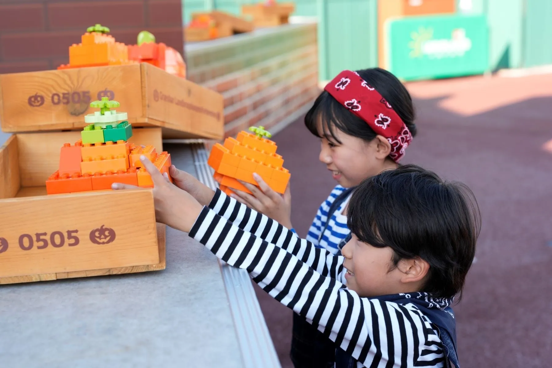 レゴブロックで作られたハロウィンかぼちゃと遊ぶ子供たち