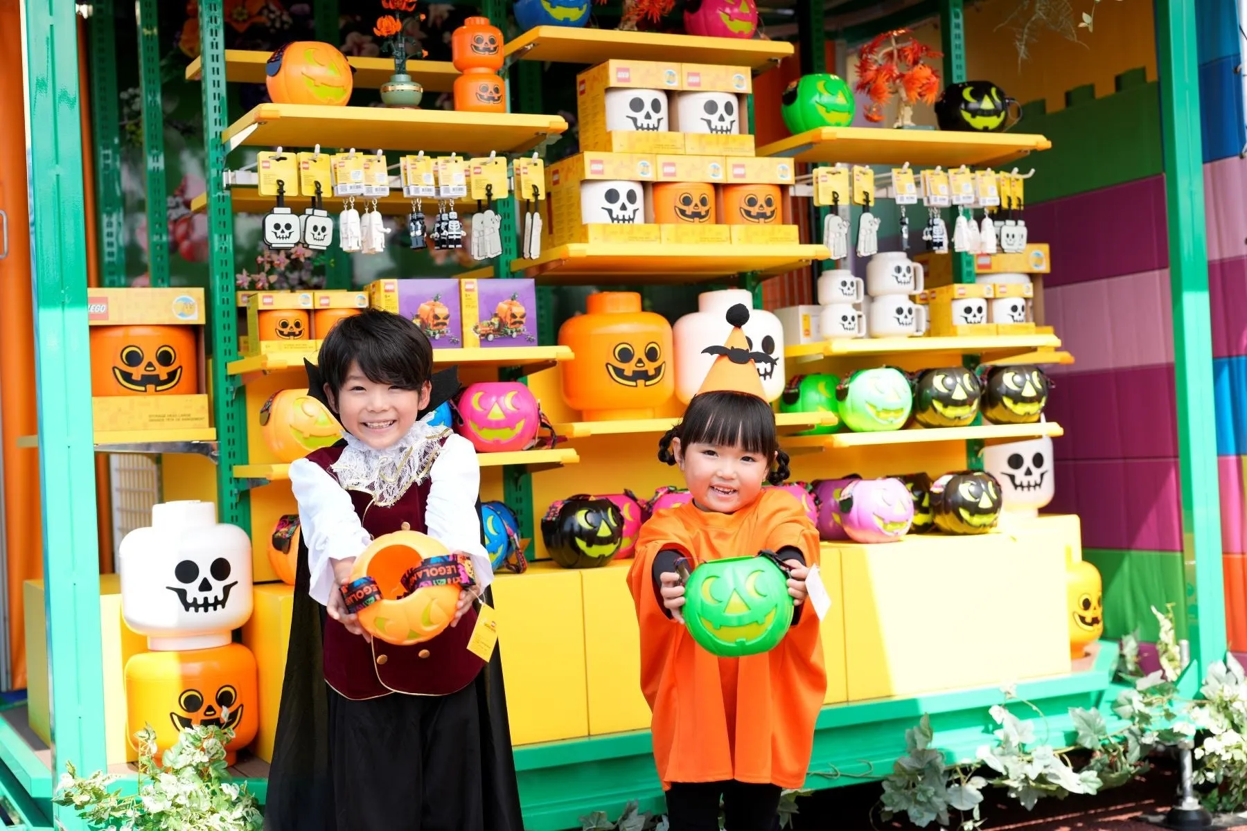 ハロウィン仮装をした子供たちとカラフルなパンプキンバケツ