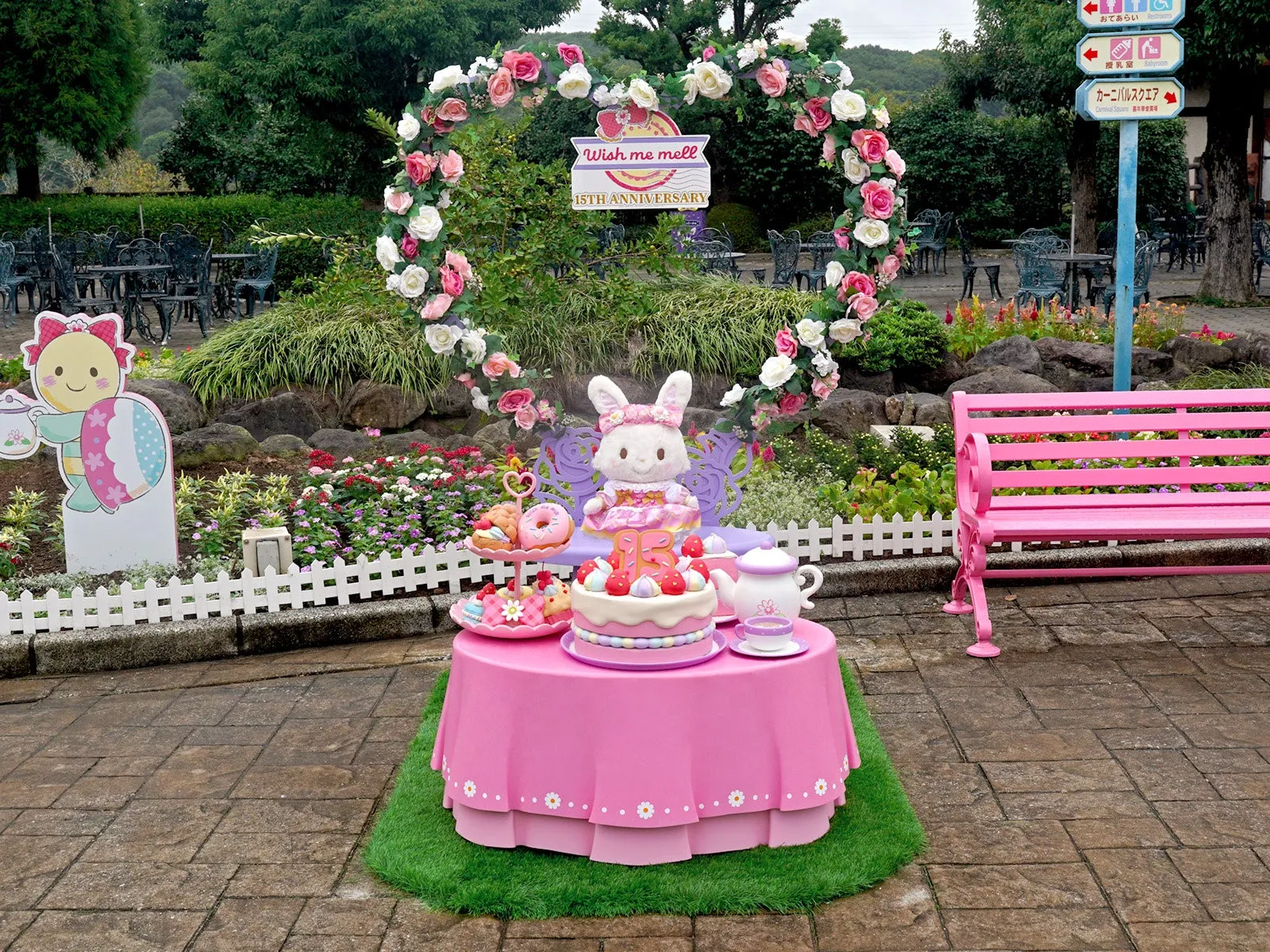 ピンクのテーブル上のウサギキャラクターとアニバーサリーケーキ