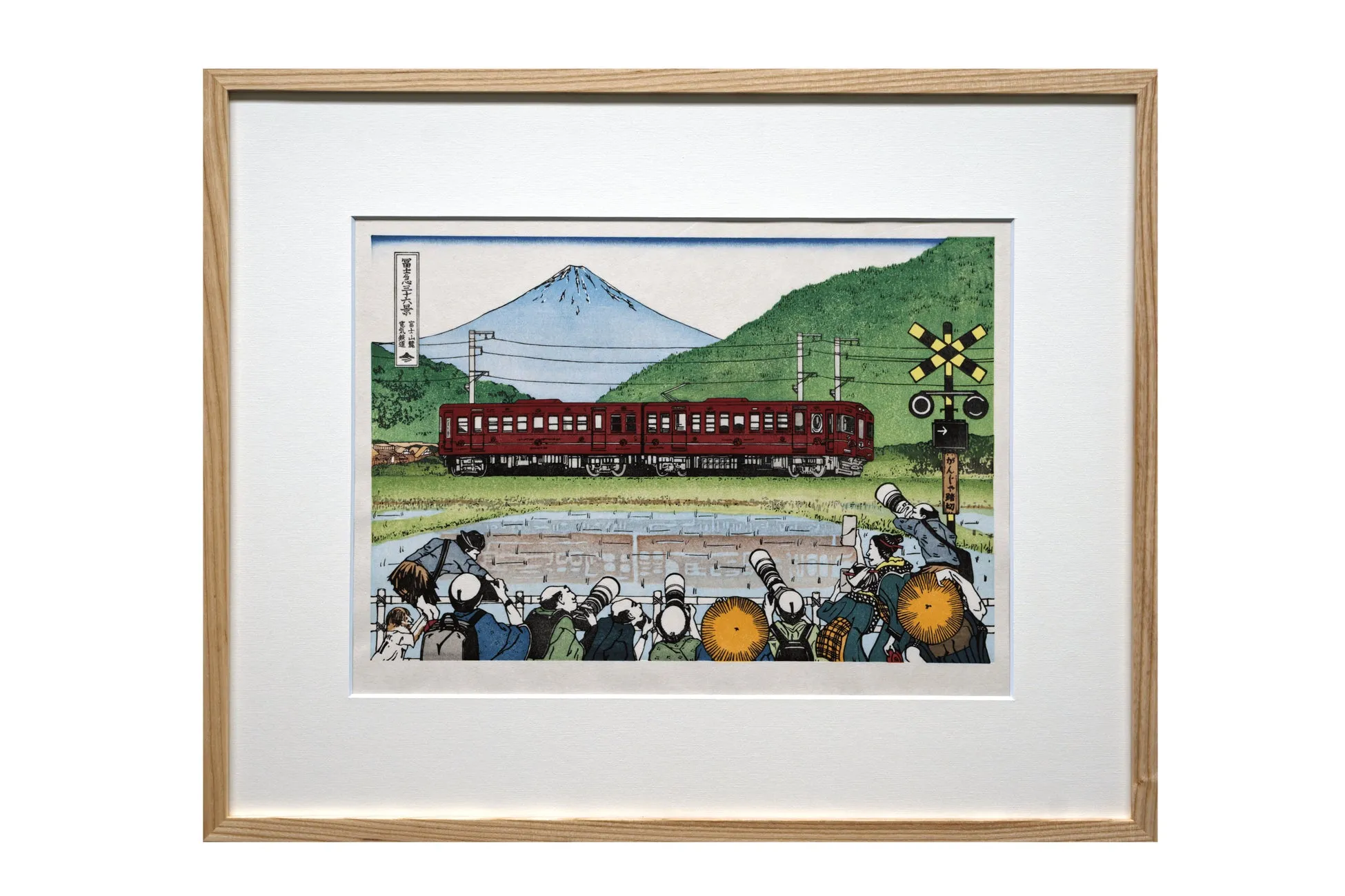 富士山を背景に走る赤い電車とカメラマン