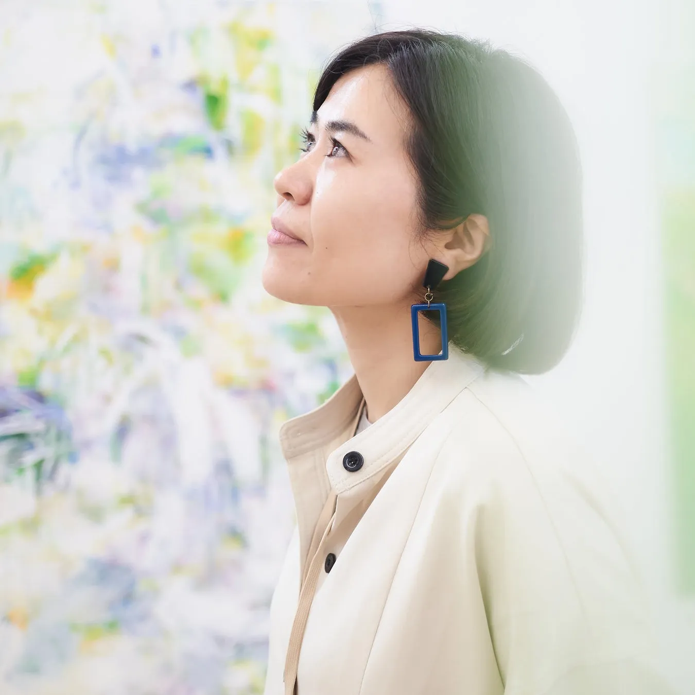 アート作品を背景に横向きの女性