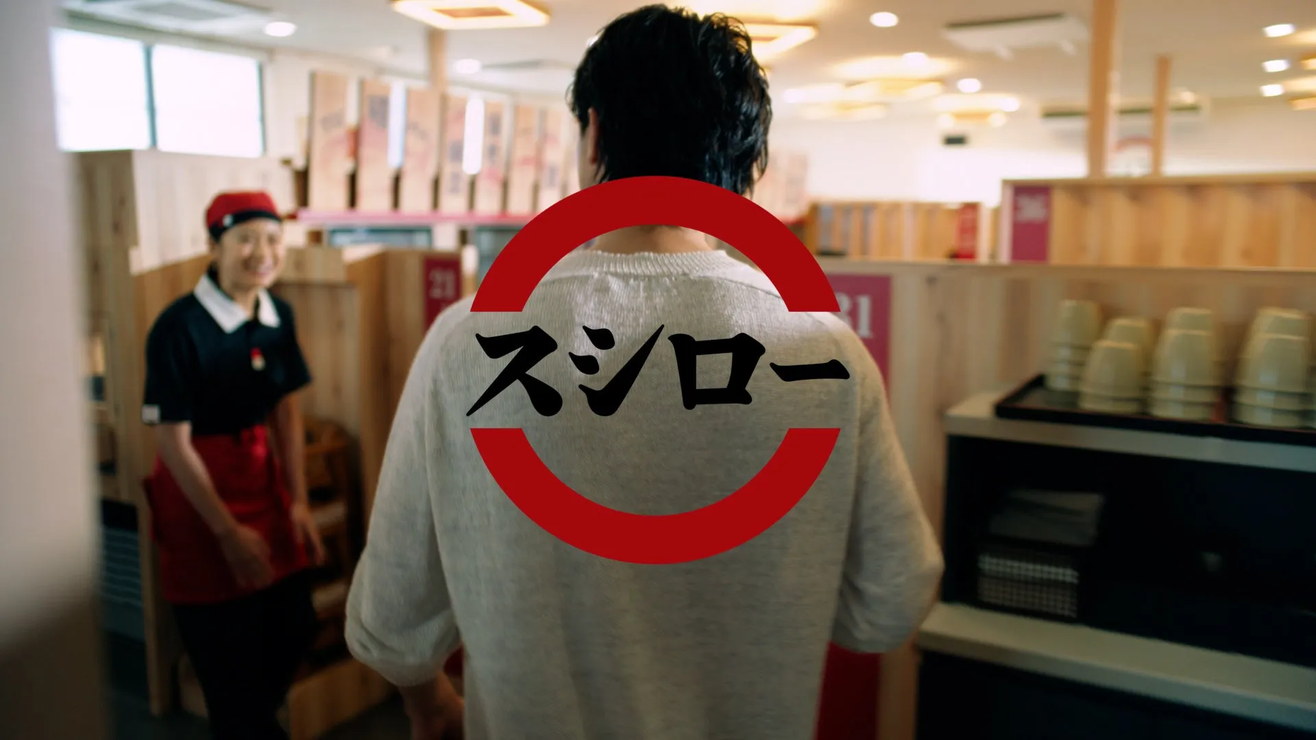 スシロー店内で俳優の後ろ姿とロゴ