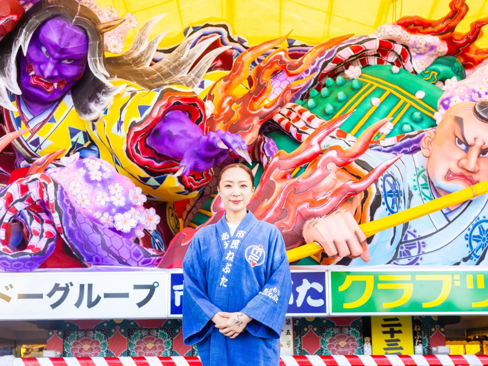 青森ねぶた祭の山車とハッピ姿の女性