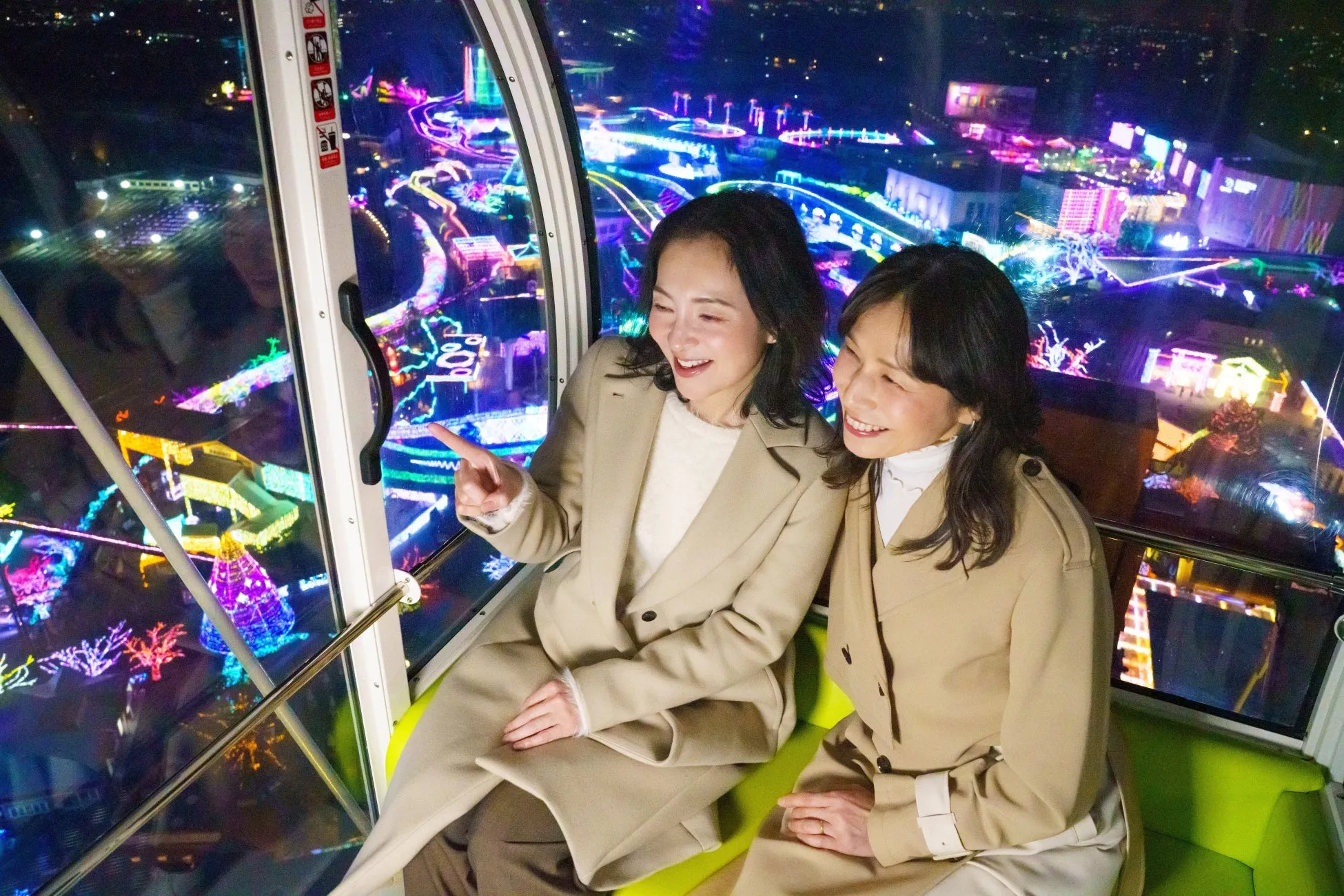 観覧車からの夜景とイルミネーションを楽しむ女性二人