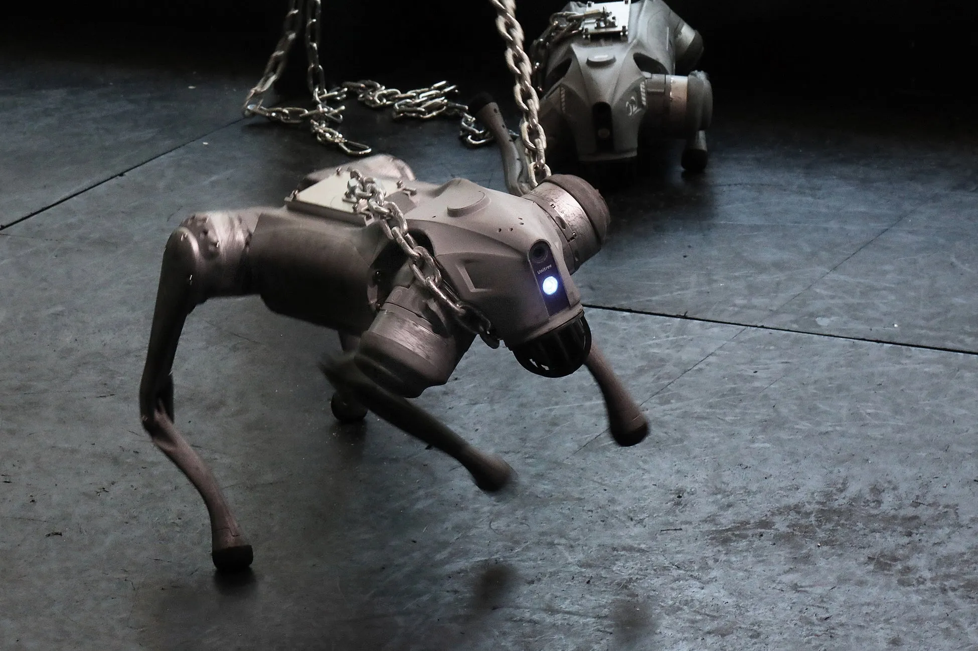 藤堂高行による鎖に繋がれ暴れ狂うロボット犬の作品