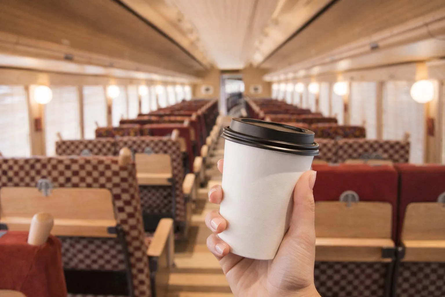 列車内でホットドリンクを持つ手