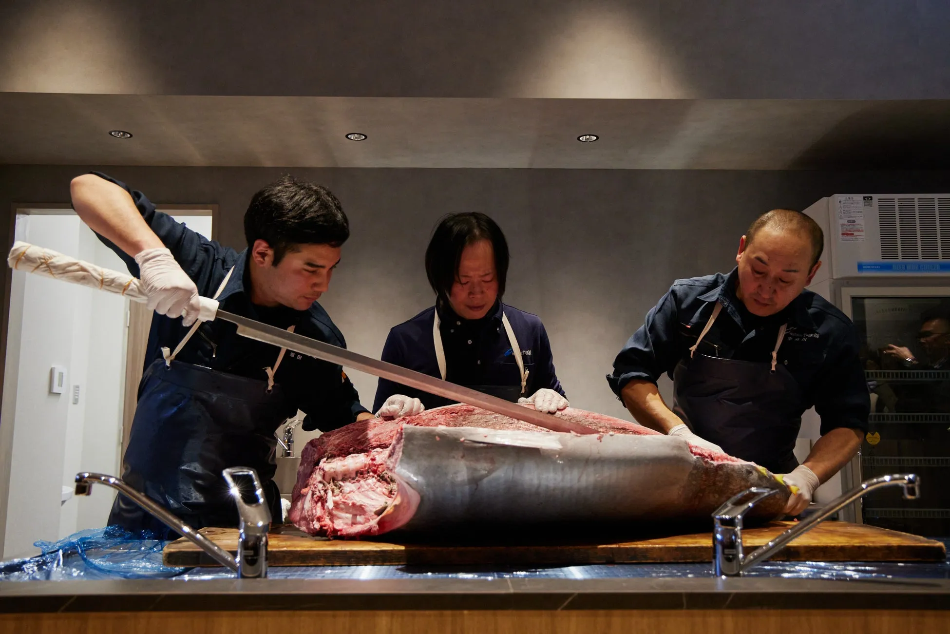 魚を解体する3人の男性