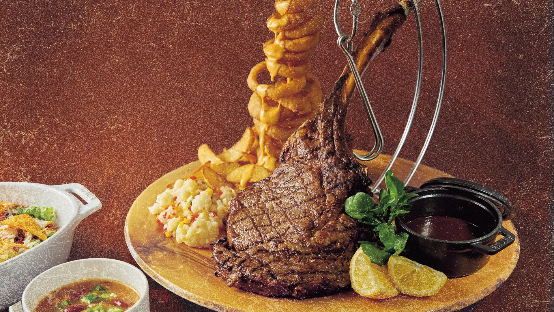 豪華な骨付きステーキとポテトの盛り合わせ