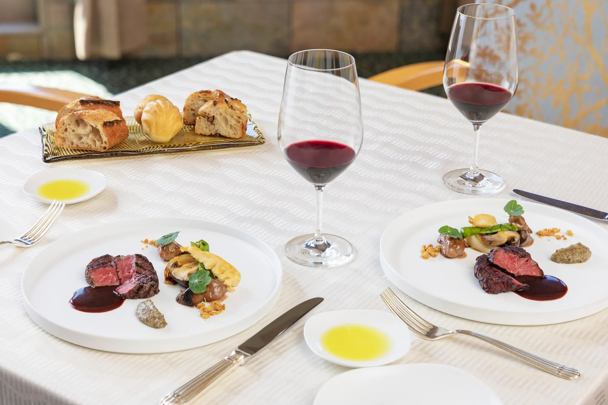 テーブルに並ぶ高級料理とレッドワイン
