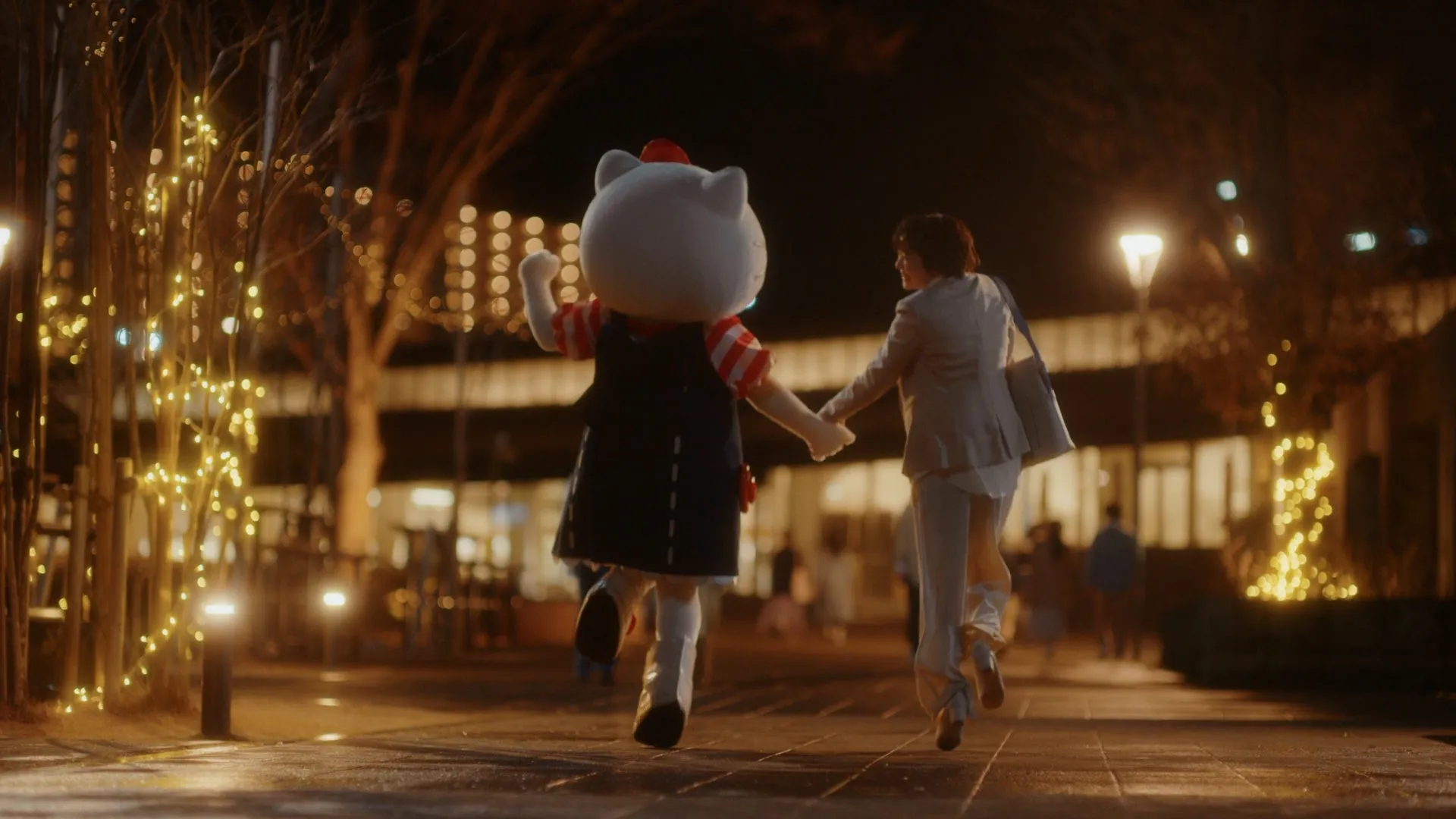 サンリオキャラクターが夜の街で手を繋いで歩くシーン