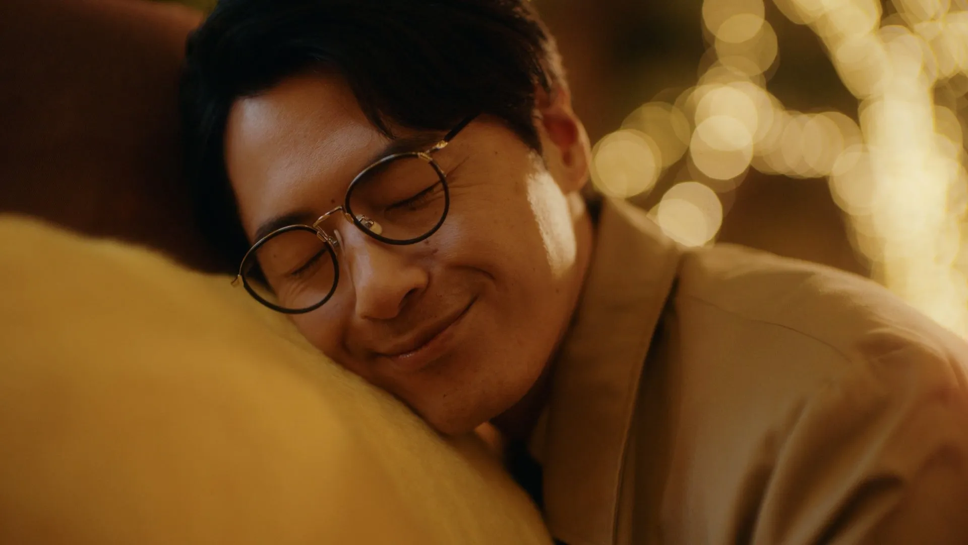 男性がぬいぐるみに頬寄せ、リラックスした表情