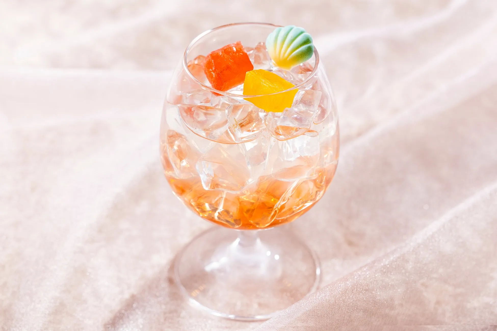 カラフルなゼリーと貝殻飾りが載ったグラスのドリンク