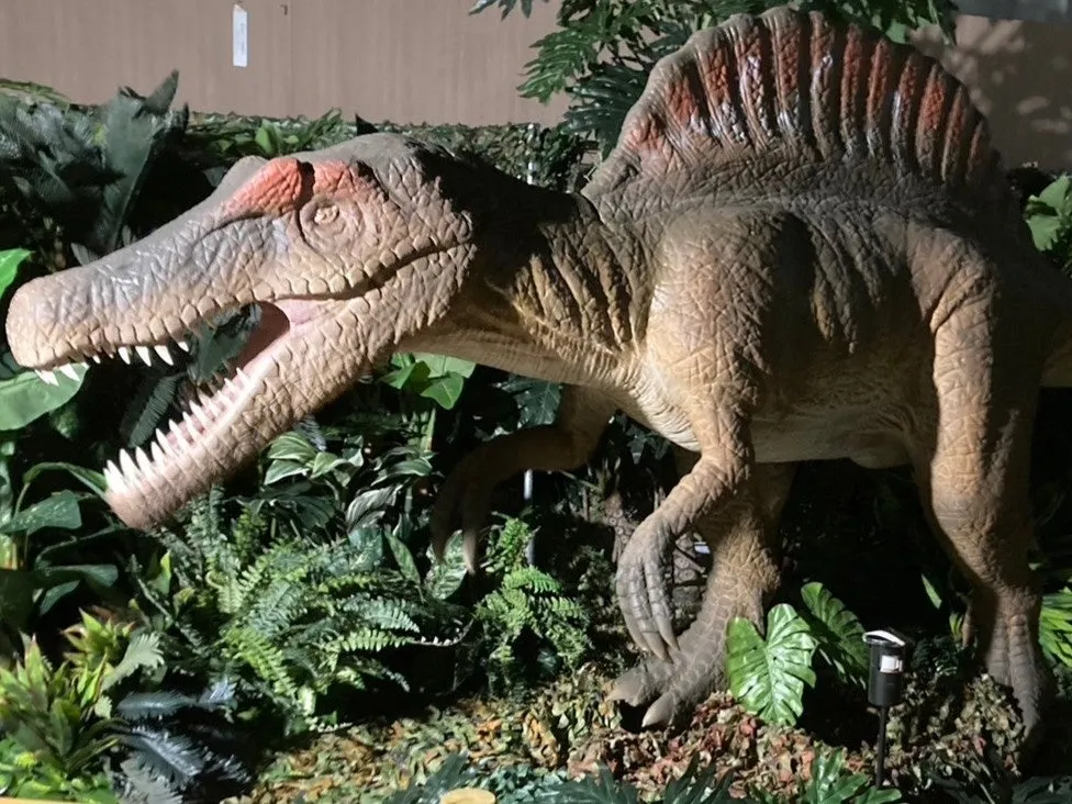 スピノサウルスの模型と豊かな緑