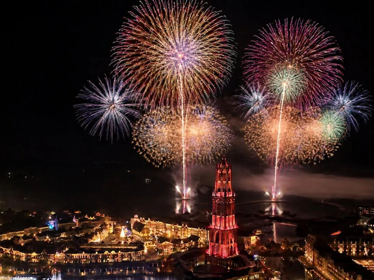夜空に打ち上がるカラフルな花火とライトアップされた建物
