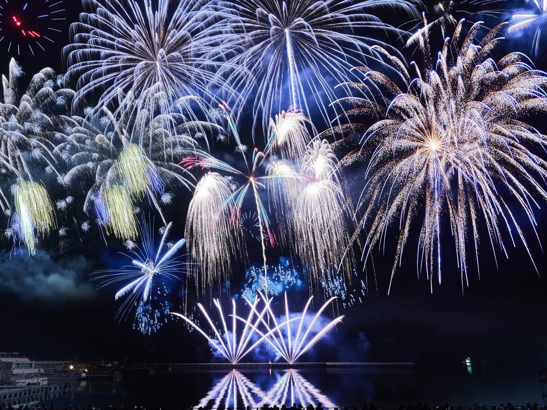 夜空を彩る美しい花火とその水面の反射