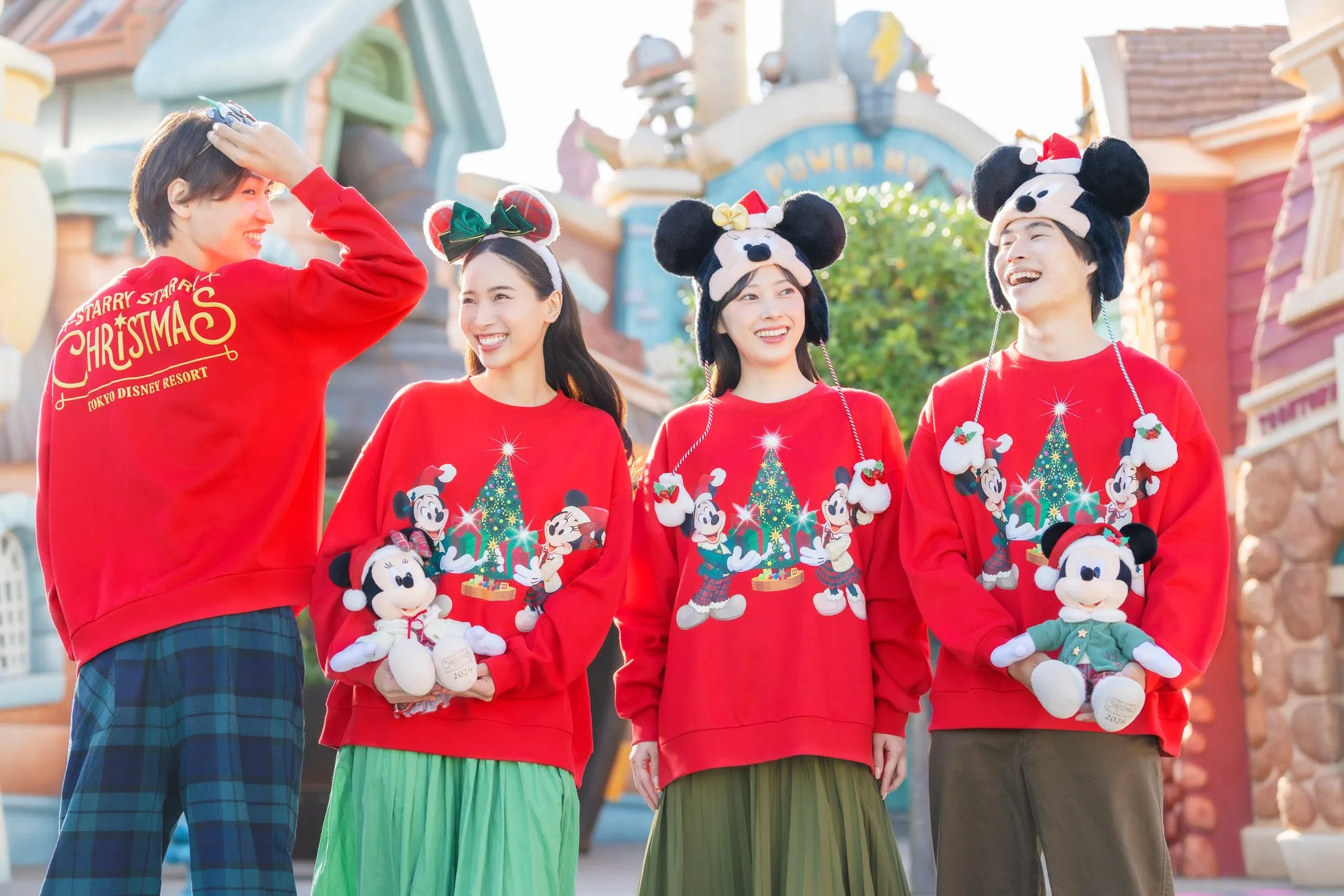 ディズニーリゾートでクリスマスを楽しむ赤いセーターの若者たち