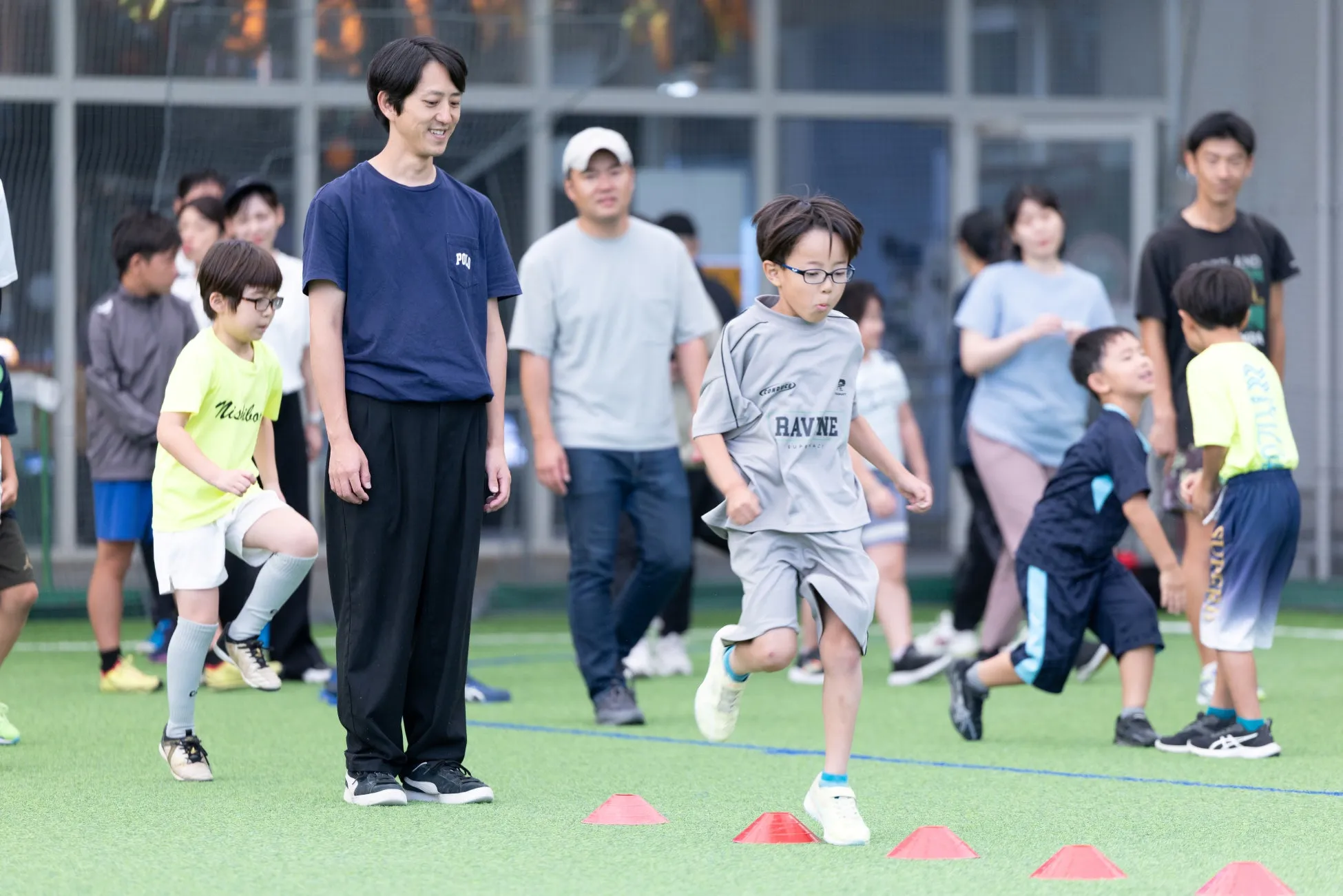 多田修平選手が見守る中、子供たちがコーンを通過