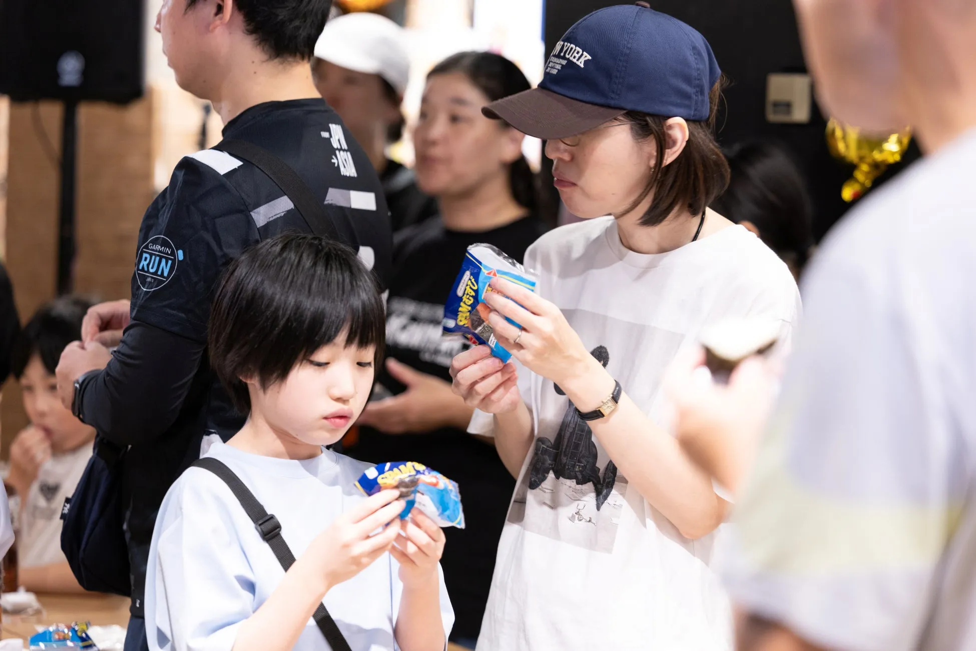 親子がイベントで軽食を楽しむ様子