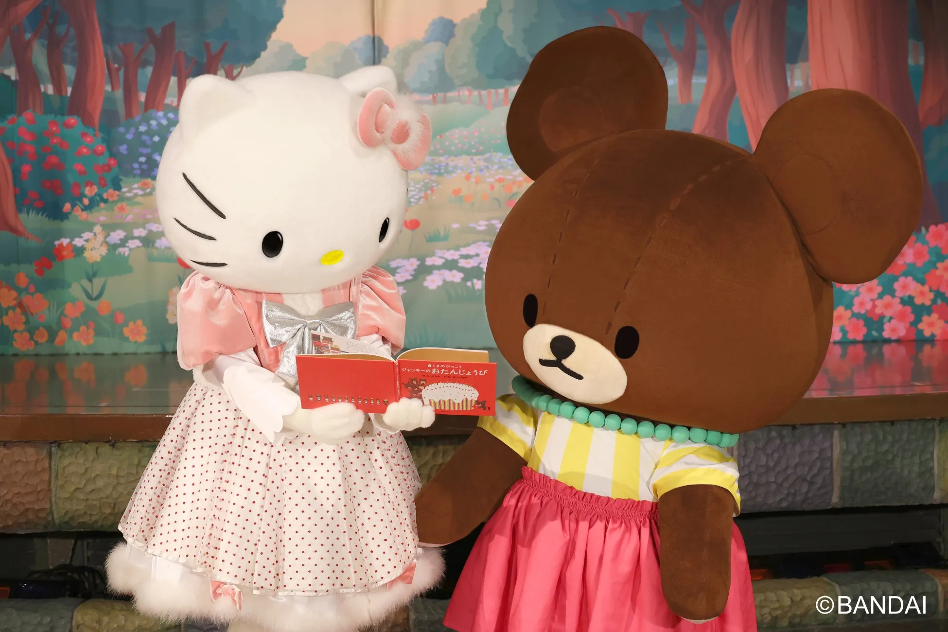 ハローキティとくまのキャラクターが本を見る様子