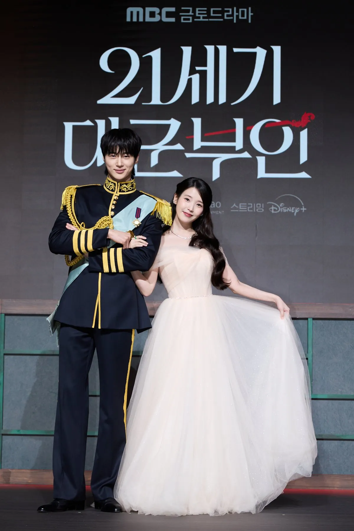 IU、デコルテ披露のプリンセスドレスで魅了　“王子”ビョン・ウソクにエスコートされ登場【『21世紀の大君夫人』会見】