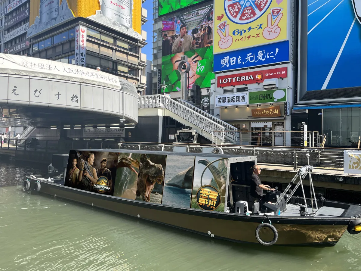 夏の道頓堀川に“恐竜”が登場　なんば地下にも“襲来”　『ジュラシック・ワールド／復活の大地』企画